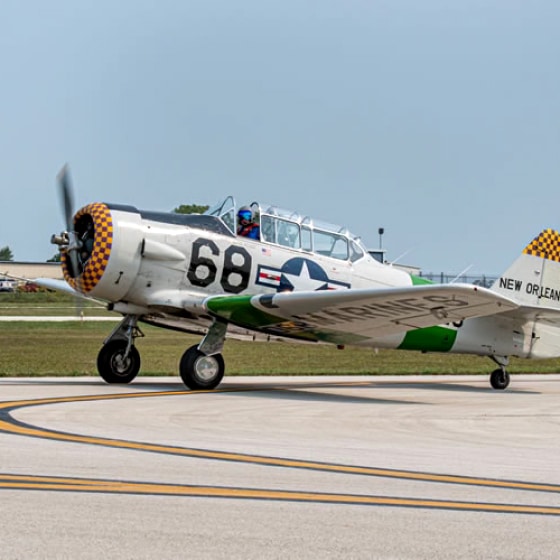 Plane on tarmac with propeller spinning. 